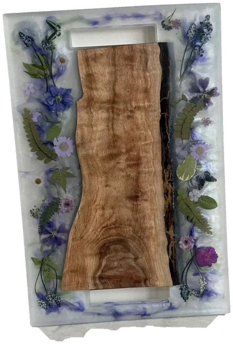 Reclaimed wood tray with a live-edge wood center and pressed flowers and butterflies floating in a pearl resin border